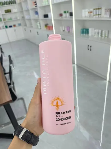 Chai dầu xả nhựa màu hồng cầm trên tay tại kho mẫu