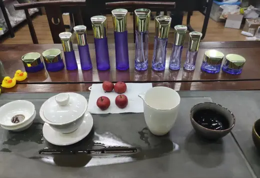 Bộ chai thủy tinh tím nắp vàng trưng bày cùng ấm trà