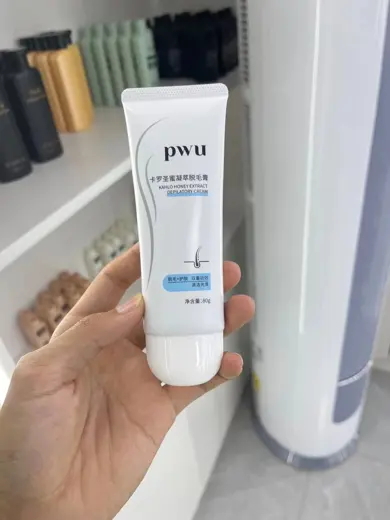 Tuýp nhựa trắng in logo xanh cầm trên tay